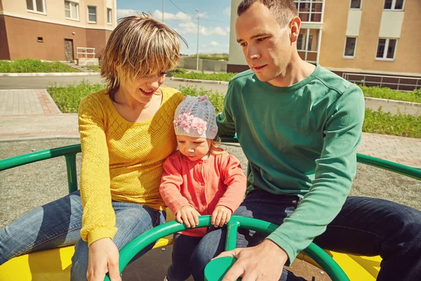Niño con los padres en un parque infantil. Mamá, papá e hija. jugar en familia . —  Fotos de Stock