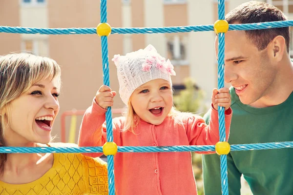 Barn med föräldrar på en lekplats. Mamma, Pappa och dotter. spela familj. — Stockfoto