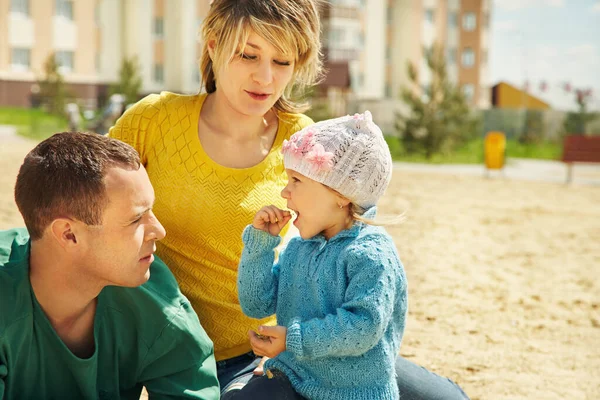 Porträtt av en lycklig spela familj utomhus. unga föräldrar med dotter på sommaren. Mamma, Pappa och barn. — Stockfoto