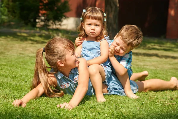 Feliz juguetón niños al aire libre en el verano en la hierba en un patio trasero . —  Fotos de Stock