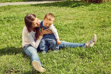 Genç anne bebeğiyle oynuyor. Anne ve oğlu dışarıda..