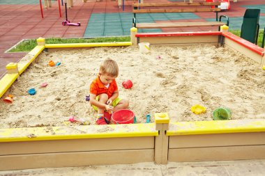 oyun üzerinde etkin küçük çocuk. Çocuk kum havuzunda oynamayı.