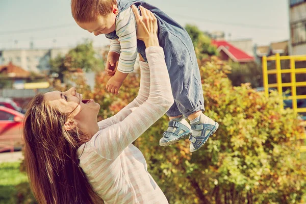 Ung mamma leker med sitt barn. Mamma och son utomhus. — Stockfoto