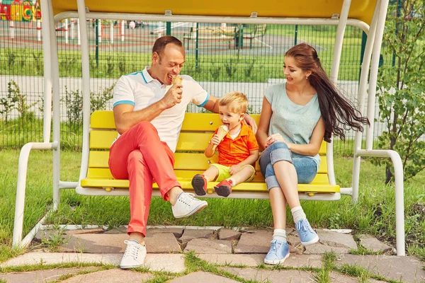 Retrato al aire libre de una familia feliz. Mamá, papá y el niño comiendo helado . —  Fotos de Stock