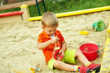 oyun üzerinde etkin küçük çocuk. Çocuk kum havuzunda oynamayı.
