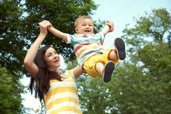 Madre con su hijo al aire libre. Madre e hijo caminando en el parque de verano . —  Fotos de Stock