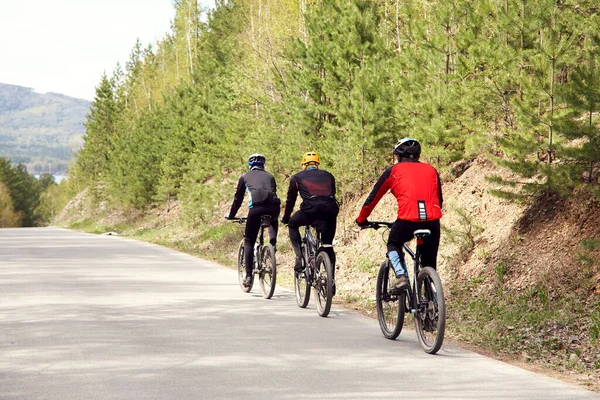 Grupp cyklister på en skogsväg — Stockfoto