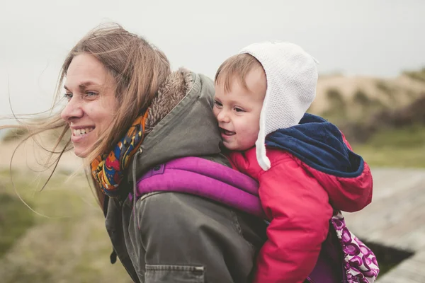 Bir sırt çantası içinde açık havada çocuğunu taşıyan anne