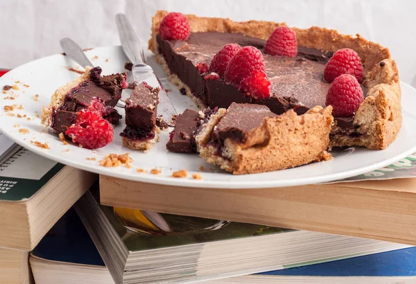 Çikolatalı kek ve ahududu üzerine bazı kitaplar ile plaka. — Stok fotoğraf