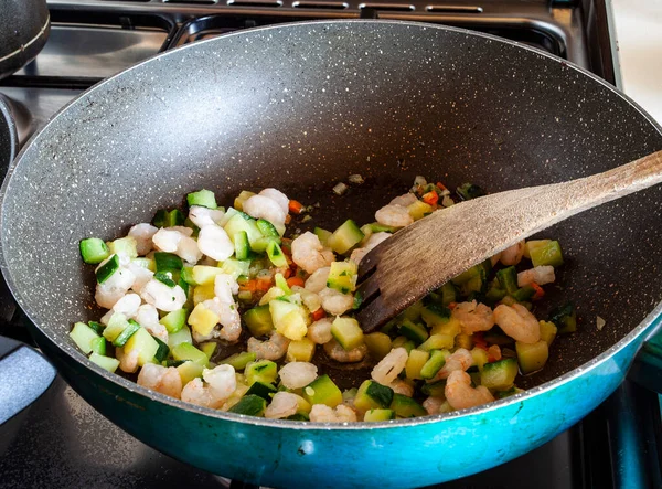 Sauce for a recipe with shrimp and zucchini in a pan on the fire