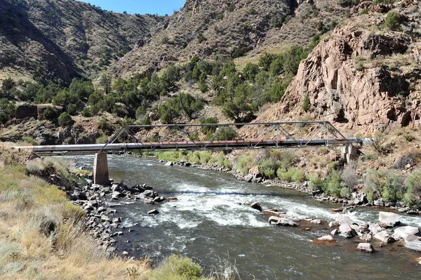 Pipeline stretching across a river between two mountains — Stock Photo, Image