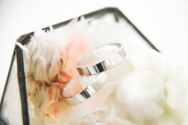 Çiçekler, dekorlar ve detaylarla dolu bir kutuda evlilik yüzükleri.