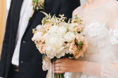 Gelin sabahı detayları. Ellerinde güzel bir buket düğün.