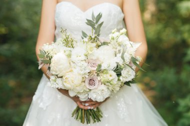 Gelin sabahı detayları. Ellerinde güzel bir buket düğün.