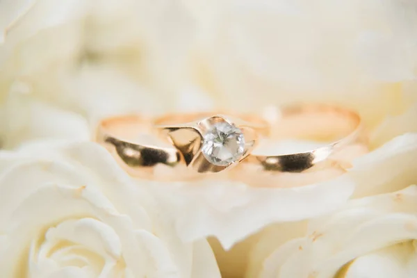 Snubní prsteny a květiny svatební kytice pozadí, — Stock fotografie