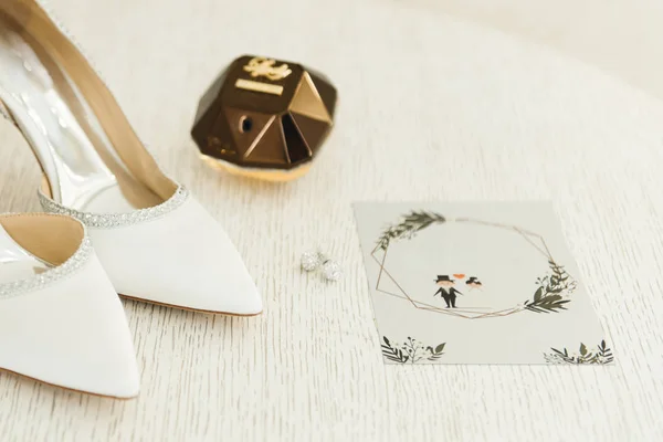 Die Details des Hochzeitstages. Brautschuhe und Einladung am — Stockfoto