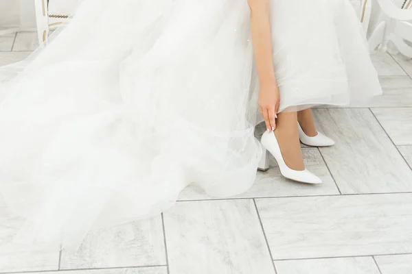 Os detalhes do dia do casamento. Noiva usa sapatos de casamento — Fotografia de Stock