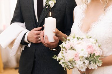 Gelin ve damat ellerinde mum tutuyorlar. Ateşleme geleneği.