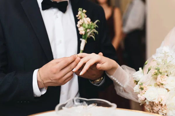 Anéis de troca de noivo e noiva de perto — Fotografia de Stock