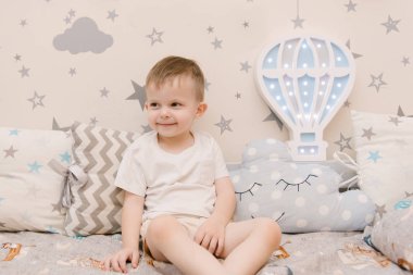 Çocuk odasında tahta bir odada oturan küçük tatlı bir oğlan.