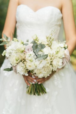 Gelin sabahı detayları. Ellerinde güzel bir buket düğün.
