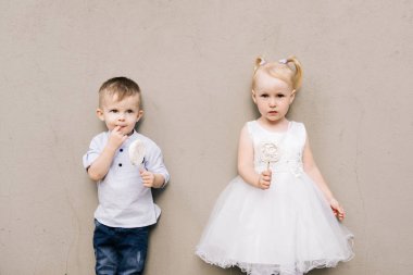 Tarz sahibi küçük bir çocuk ve kız gri bir arka planda ve şekerli Meri