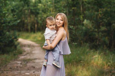 Mutlu genç aile doğada birlikte zaman geçirir. Bebekli tatlı anne