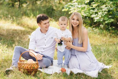 Mutlu genç aile doğada birlikte zaman geçirir. Ormanda piknik.