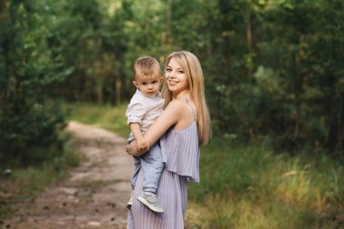 Mutlu genç aile doğada birlikte zaman geçirir. Bebekli tatlı anne