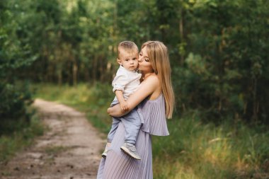 Mutlu genç aile doğada birlikte zaman geçirir. Bebekli tatlı anne