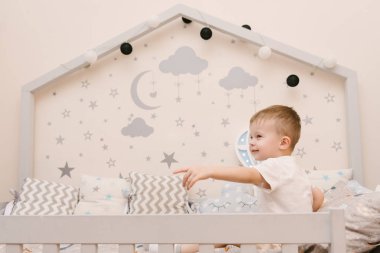 Çocuk odasında tahta bir odada oturan küçük tatlı bir oğlan.