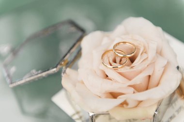 Çiçekler, dekorlar ve detaylarla dolu bir kutuda evlilik yüzükleri.