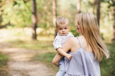 Mutlu genç aile doğada birlikte zaman geçirir. Bebekli tatlı anne