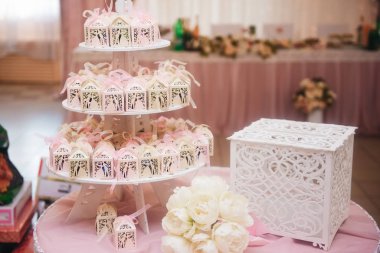 Yeni evlilere verilecek bir masa. Düğün şekerleri, beyaz. Hediyeler
