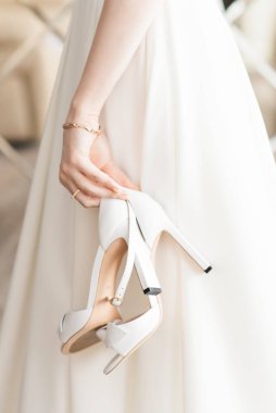 Düğün gününün detayları. Ayakkabılar gelinin elinde.