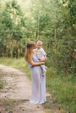 Mutlu genç aile doğada birlikte zaman geçirir. Bebekli tatlı anne