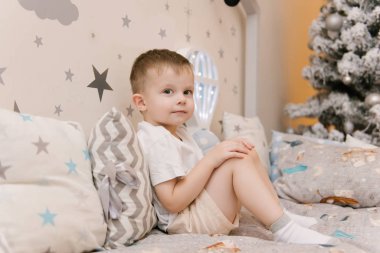 Küçük tatlı bebek çocuk, çocuk odasında tahta bir odada oturuyor. 