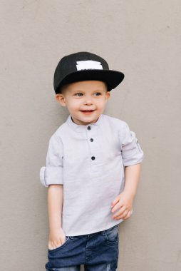 Gri arka planda mutlu stil sahibi erkek bebek