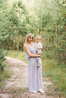 Mutlu genç aile doğada birlikte zaman geçirir. Bebekli tatlı anne
