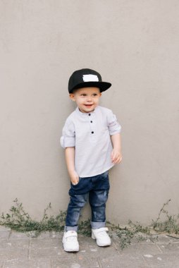Gri arka planda mutlu stil sahibi erkek bebek