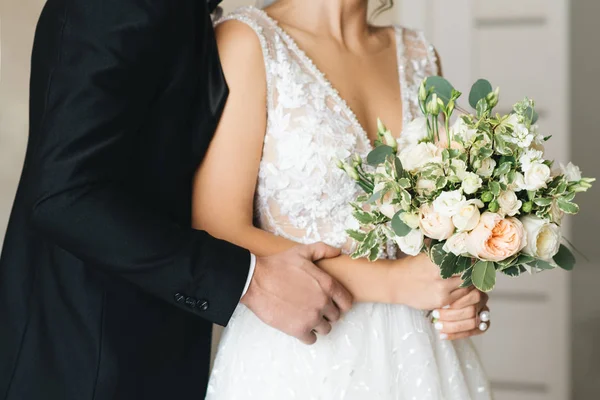 Руки жениха и невесты с букетами крупным планом — стоковое фото