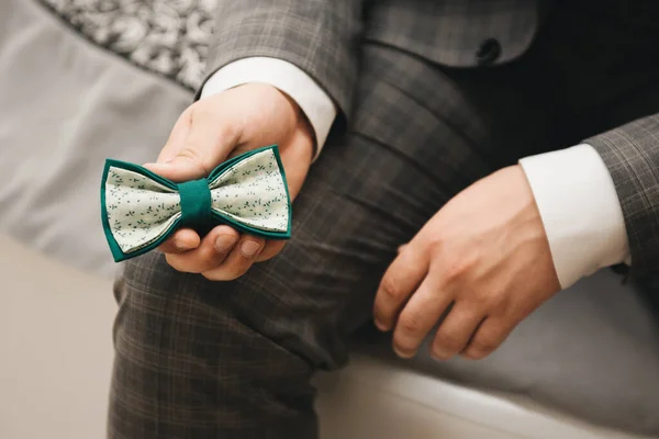 Grüne Fliege in den Händen des Bräutigams. Hochzeitstag — Stockfoto