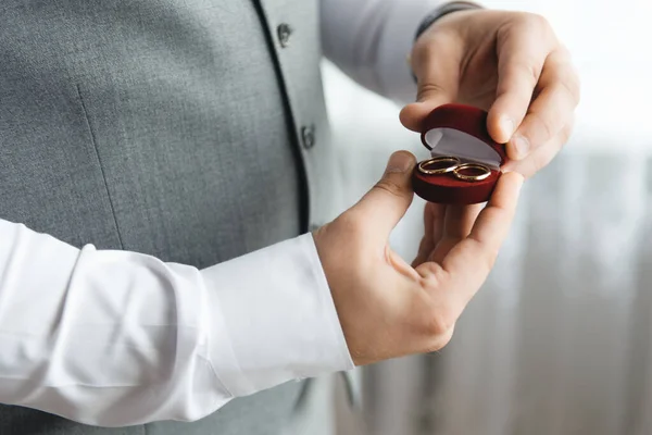 A box of wedding rings in a man\'s hands.