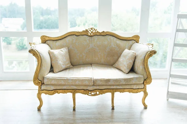 Classic retro sofa with gold inserts stands on the background of — Stock Photo, Image