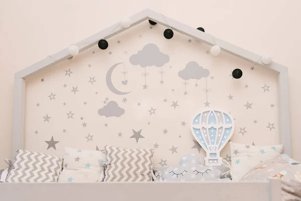 Hölzernes grauweißes Babybett in Form eines Hauses mit Sternen und — Stockfoto