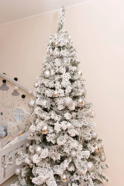 Snötäckt vit julgran med silverleksaker och ett rådjur i — Stockfoto