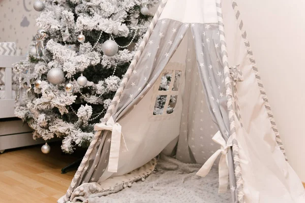 Árvore de Natal e wigwam na sala de crianças. Decorações de Natal . — Fotografia de Stock