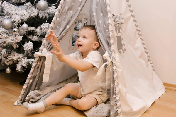 Ein kleiner süßer Junge sitzt im Kinderzimmer in einem zehn — Stockfoto