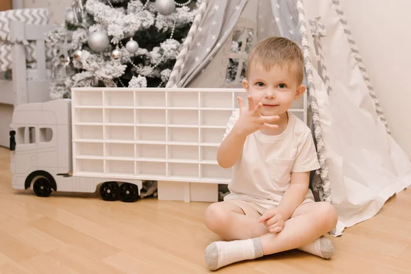 Маленький милый мальчик сидит в детской комнате в вигваме и — стоковое фото