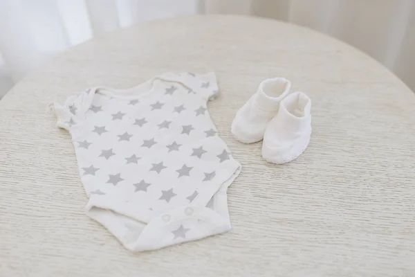 Cute zdjęcie ubrań dla noworodka. Biały kombinezon, buty. — Zdjęcie stockowe
